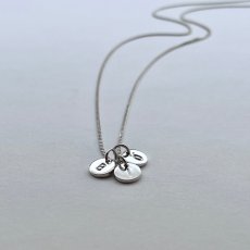 Miini is a tiny charm in sterling silver personalized with a letter or at symbol.